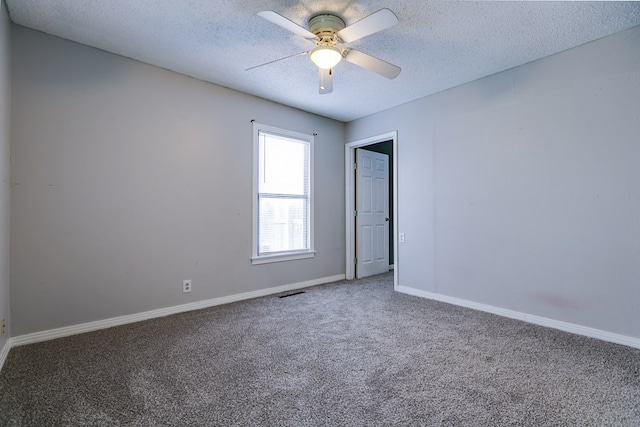 empty room with ceiling fan, carpet floors, and a textured ceiling