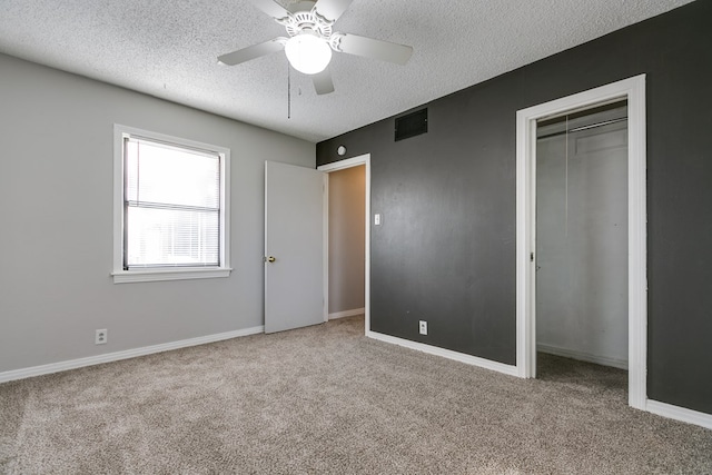 unfurnished bedroom with light carpet, a textured ceiling, and ceiling fan