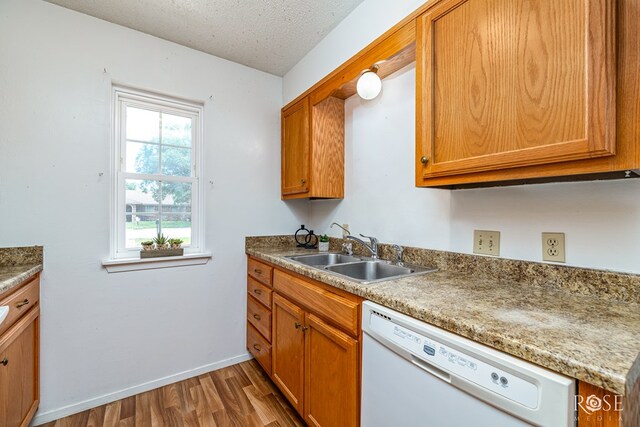 25 Dellwood Dr, San Angelo, TX 76903 - kitchen featuring dishwasher, wood finished floors, a textured ceiling, and brown cabinets