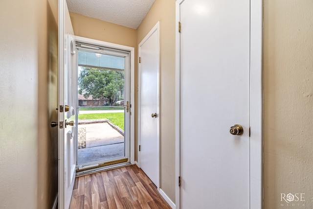 25 Dellwood Dr, San Angelo, TX 76903 - doorway to outside featuring wood finished floors and a textured ceiling