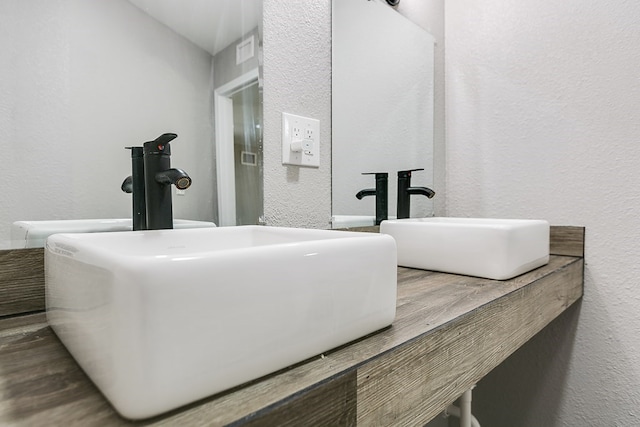 6622 Knickerbocker Rd, San Angelo, TX 76904 - bathroom with a textured wall, wood finished floors, and double vanity