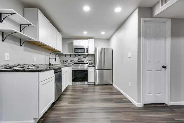 6622 Knickerbocker Rd, San Angelo, TX 76904 - kitchen with appliances with stainless steel finishes, open shelves, dark countertops, dark wood finished floors, and white cabinets