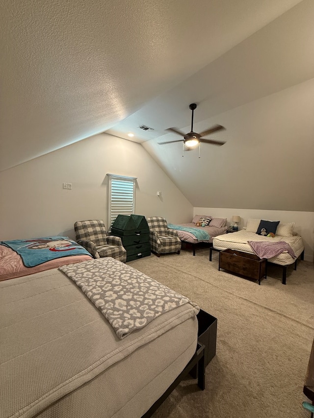 carpeted bedroom featuring visible vents, vaulted ceiling, a textured ceiling, and ceiling fan