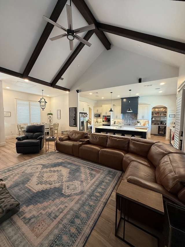 living room with a ceiling fan, wood finished floors, beamed ceiling, high vaulted ceiling, and recessed lighting