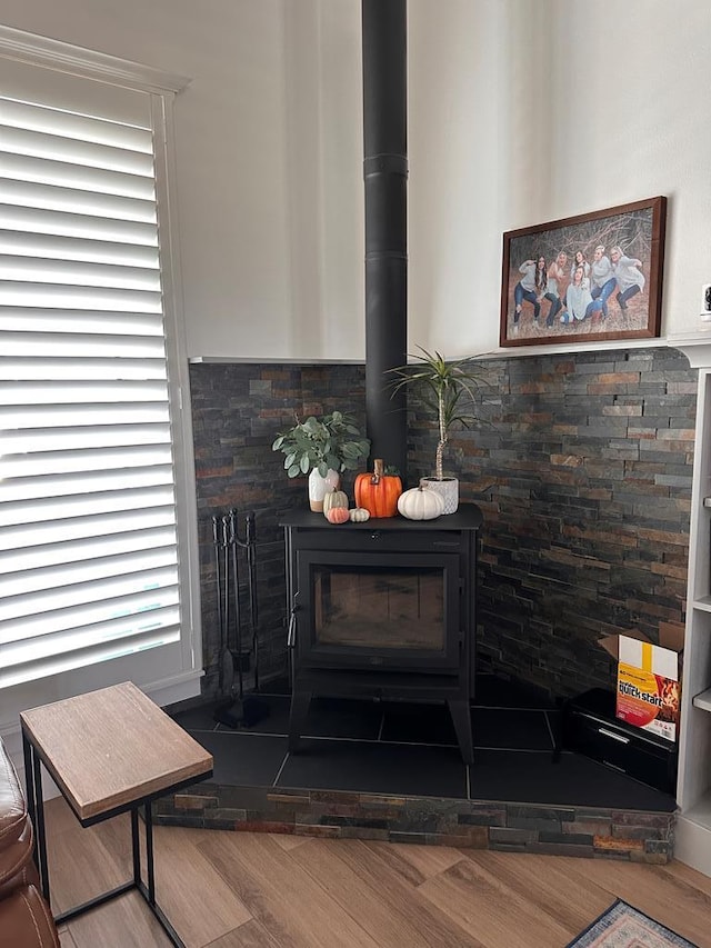 interior details with a wood stove and wood finished floors