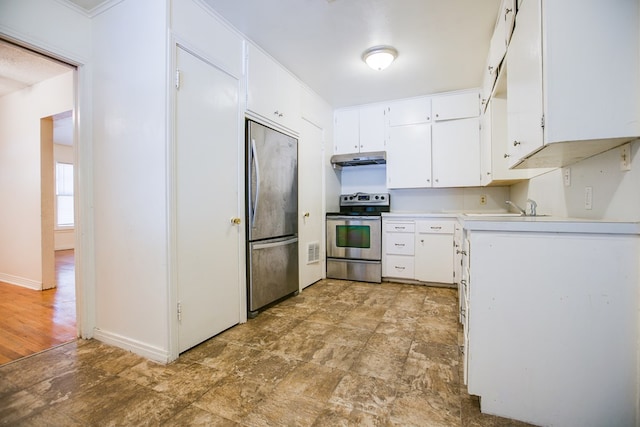 1309 5th Ave, Ballinger, TX 76821 - kitchen with stainless steel appliances, under cabinet range hood, white cabinetry, light countertops, and stone finish floors