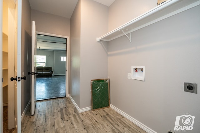 washroom featuring washer hookup, hookup for an electric dryer, and light hardwood / wood-style flooring