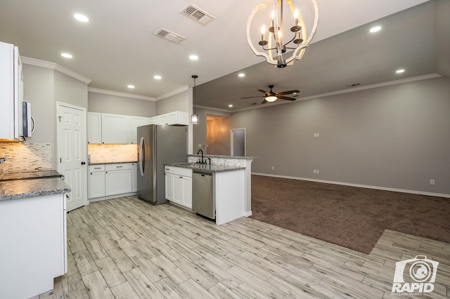 kitchen with decorative light fixtures, stainless steel appliances, decorative backsplash, and white cabinets