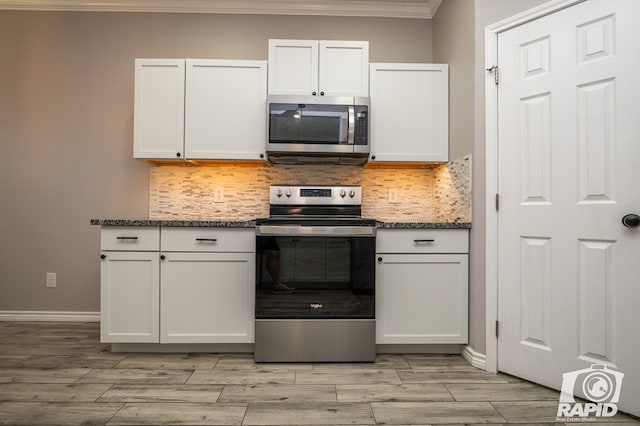 kitchen featuring backsplash, crown molding, stainless steel appliances, and white cabinets