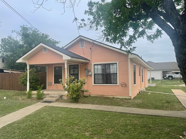 bungalow-style house with a front lawn, fence, and covered porch