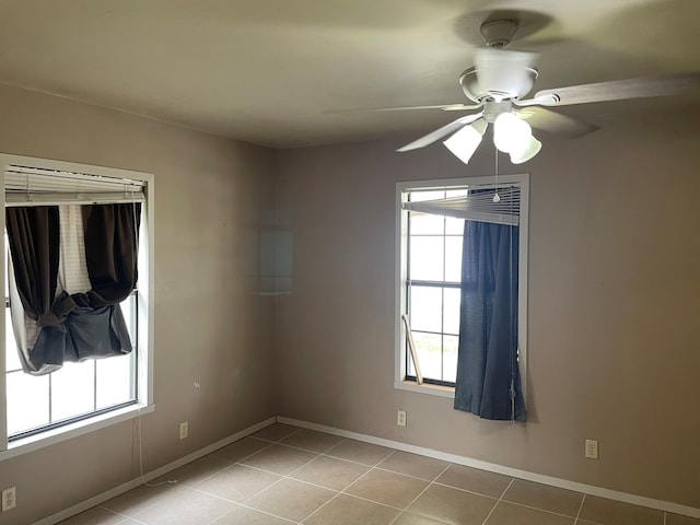 spare room with light tile patterned floors, baseboards, and a ceiling fan