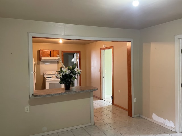 interior space featuring light tile patterned flooring and baseboards