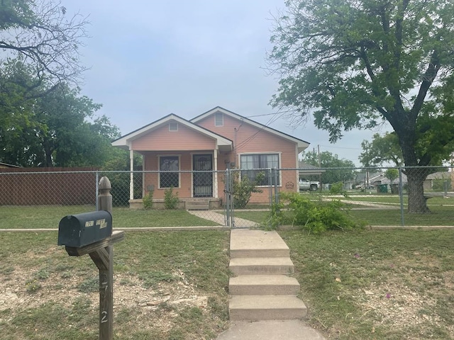 bungalow-style home featuring a gate, fence private yard, and a front lawn