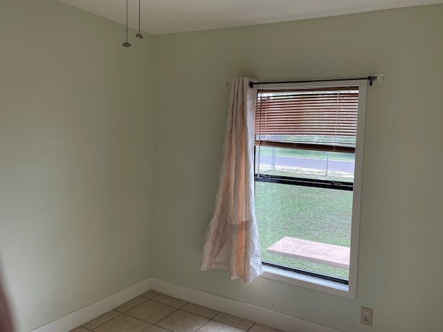 unfurnished room featuring light tile patterned flooring and baseboards