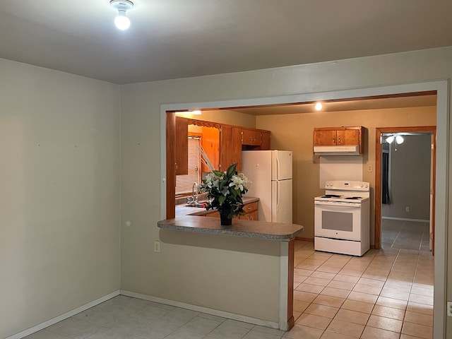 kitchen with a peninsula, white appliances, under cabinet range hood, brown cabinets, and light tile patterned floors