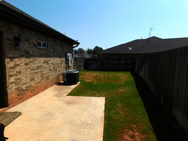 view of yard with central AC and a patio