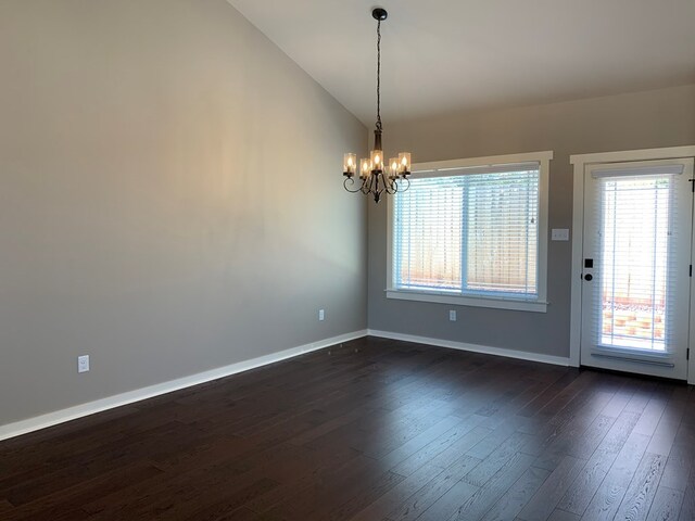 unfurnished room with lofted ceiling, dark wood-type flooring, and a notable chandelier