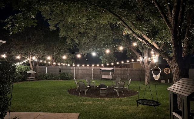 6033 Winners Cir, San Angelo, TX 76904 - yard at twilight with a fenced backyard and a fire pit