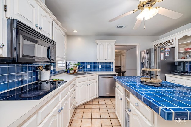6033 Winners Cir, San Angelo, TX 76904 - kitchen featuring black appliances, white cabinets, tile counters, and recessed lighting