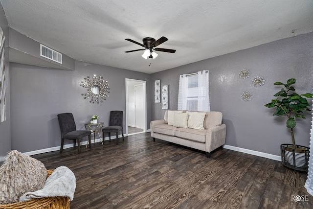 living room with a textured ceiling, dark hardwood / wood-style floors, and ceiling fan