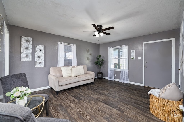 living room with a textured ceiling, dark hardwood / wood-style floors, and ceiling fan