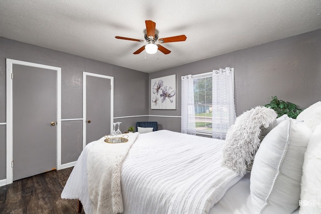 bedroom featuring dark hardwood / wood-style floors, a textured ceiling, and ceiling fan