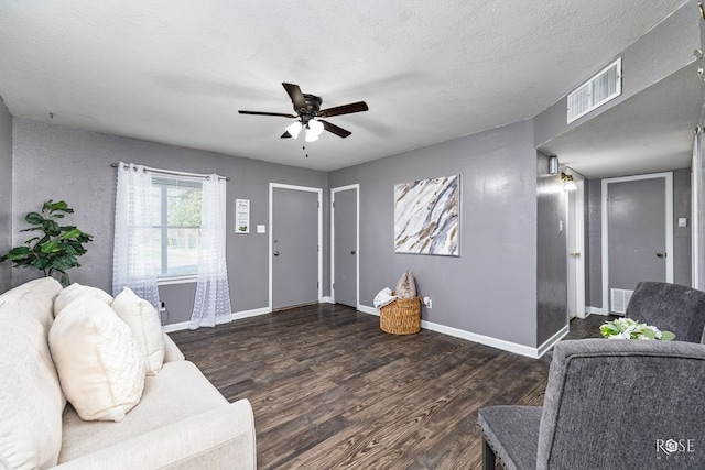 living room featuring ceiling fan, dark hardwood / wood-style flooring, and a textured ceiling