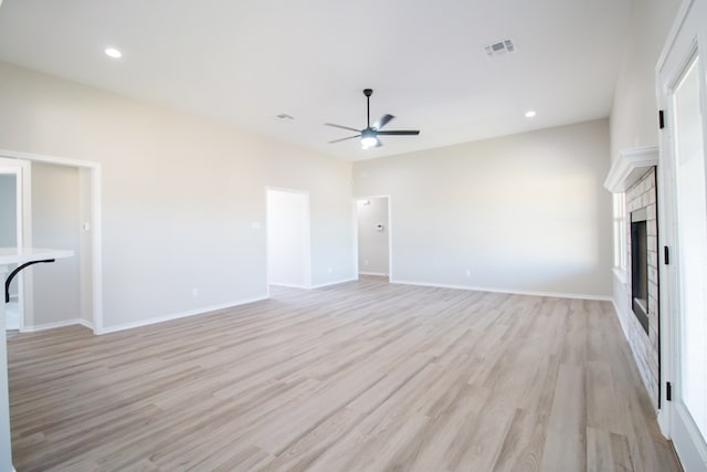 unfurnished living room featuring a wealth of natural light, ceiling fan, and light hardwood / wood-style flooring