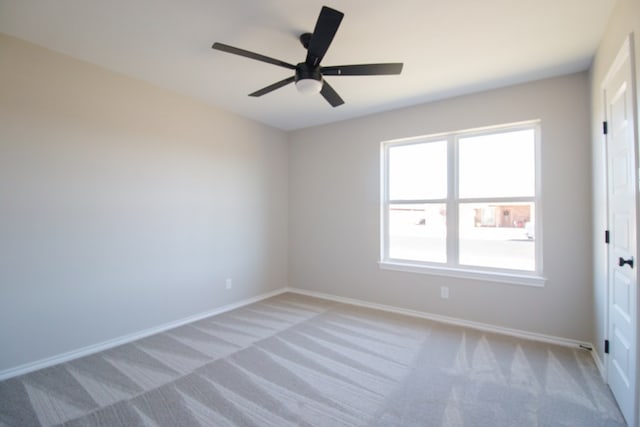 empty room with ceiling fan and light colored carpet