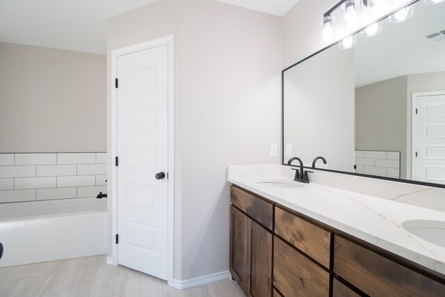 bathroom featuring vanity and a bath