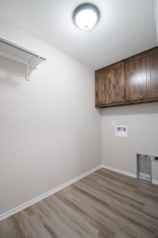 washroom featuring cabinets, washer hookup, hardwood / wood-style floors, and hookup for an electric dryer