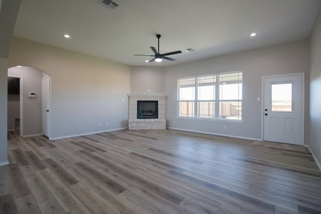 unfurnished living room featuring ceiling fan, a fireplace, and light hardwood / wood-style floors