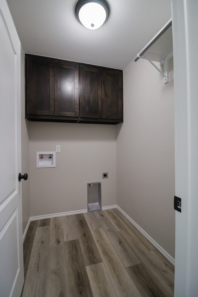 washroom with washer hookup, cabinets, light hardwood / wood-style floors, and electric dryer hookup