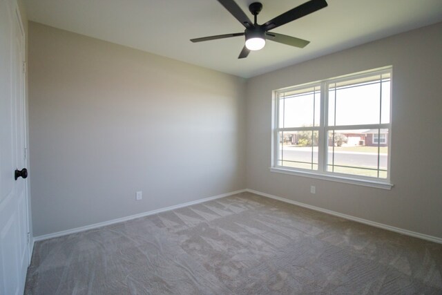 empty room with ceiling fan and carpet