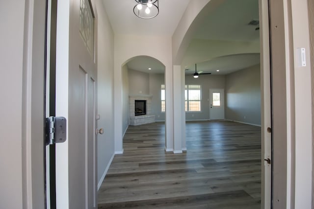 entryway featuring ceiling fan, a fireplace, and dark hardwood / wood-style flooring