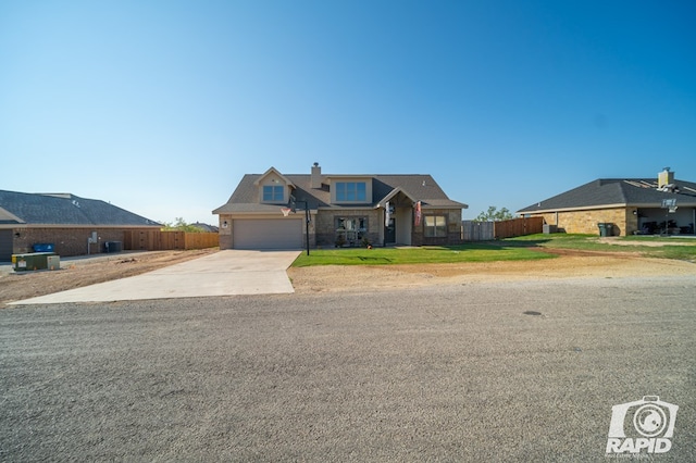 view of front facade with fence, concrete driveway, a front yard, a chimney, and a garage