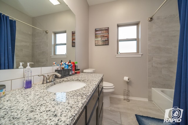 bathroom with shower / bathtub combination with curtain, baseboards, toilet, and vanity