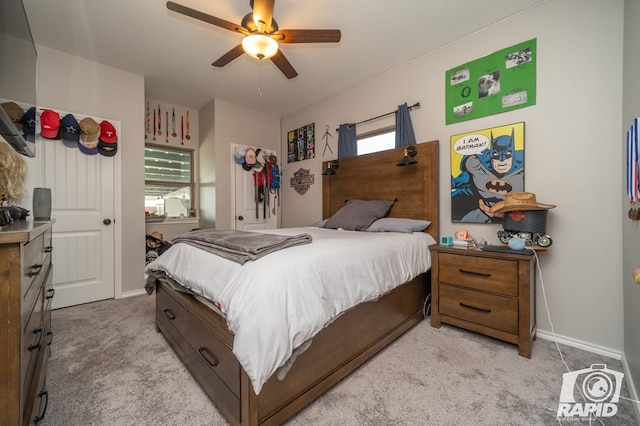 bedroom featuring light colored carpet, baseboards, and ceiling fan