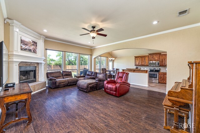 3926 Caroline Ln, San Angelo, TX 76904 - living room featuring arched walkways, ceiling fan, wood finished floors, a large fireplace, and ornamental molding