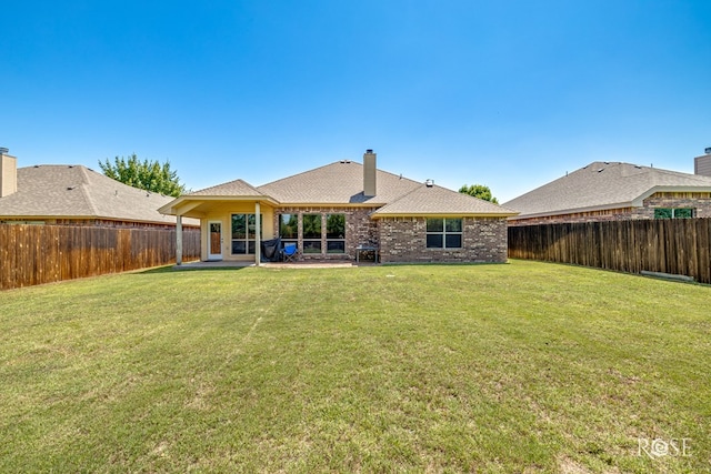 3926 Caroline Ln, San Angelo, TX 76904 - rear view of house with a fenced backyard, a chimney, brick siding, a patio, and roof with shingles