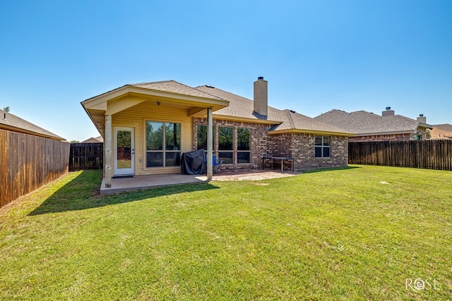3926 Caroline Ln, San Angelo, TX 76904 - back of property with a patio area, a fenced backyard, a chimney, and brick siding