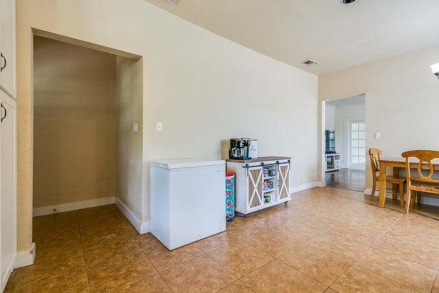 3805 Ogden St, San Angelo, TX 76903 - kitchen with light tile patterned floors, white fridge, baseboards, and light countertops