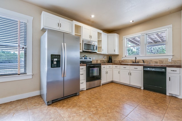 3805 Ogden St, San Angelo, TX 76903 - kitchen with stainless steel appliances, open shelves, tile countertops, white cabinetry, and recessed lighting