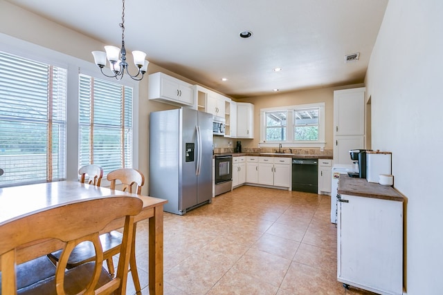3805 Ogden St, San Angelo, TX 76903 - kitchen featuring stainless steel appliances, dark countertops, a sink, a chandelier, and white cabinets