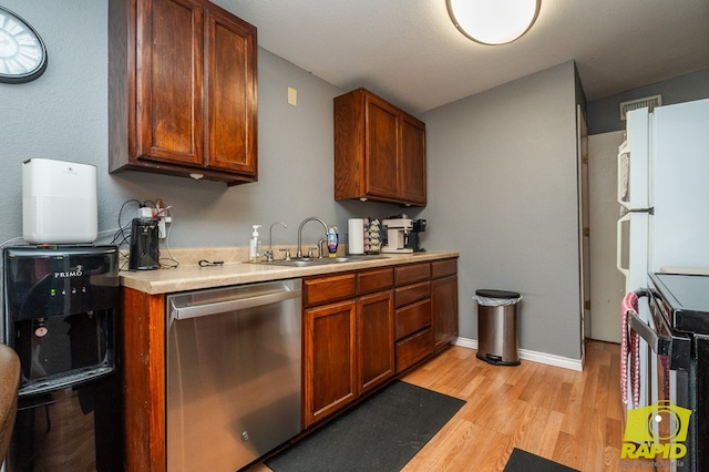2123 Wilson St, San Angelo, TX 76901 - kitchen with stainless steel dishwasher, a sink, electric range oven, light wood-style floors, and light countertops