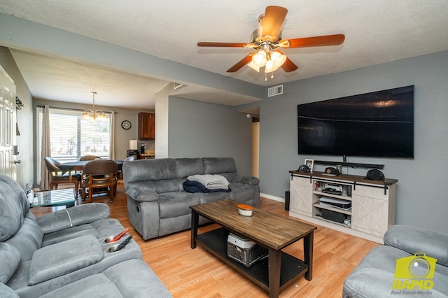 2123 Wilson St, San Angelo, TX 76901 - living room featuring a chandelier, a ceiling fan, and light wood-style floors