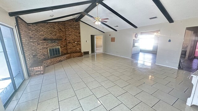 unfurnished living room featuring lofted ceiling with beams, light tile patterned floors, ceiling fan, a brick fireplace, and a textured ceiling