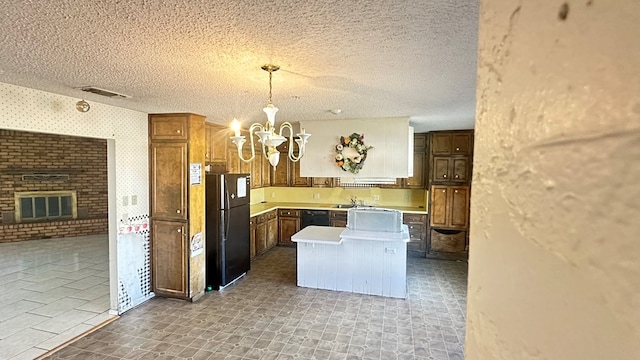 kitchen with decorative light fixtures, a chandelier, a textured ceiling, a fireplace, and black appliances