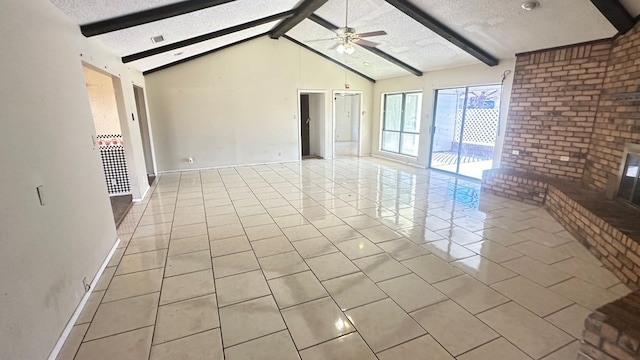 unfurnished living room featuring ceiling fan, light tile patterned floors, a textured ceiling, and vaulted ceiling with beams