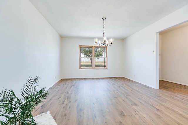 7077 Bean Rd, Wall, TX 76957 - spare room with a chandelier, light wood-type flooring, and baseboards